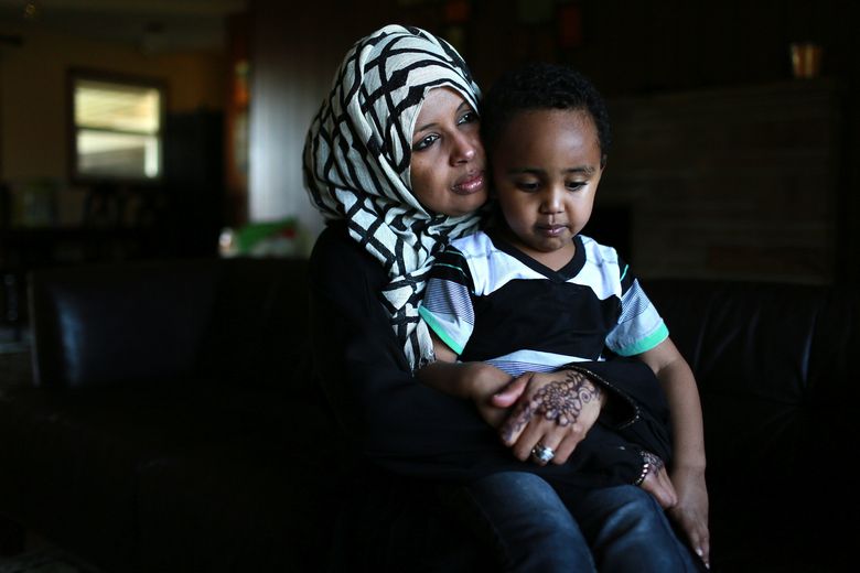 <strong>Fearing for relatives:</strong>Kadija Hussein, 34, owner of a Tukwila day care, holds son Ayyub Osmond, 3, one of her four children. She and her husband, a Port of Seattle truck driver, send about $500 a month back to family in Somalia, helping keep relatives’ children in school, food on the table and roofs over their heads. “In Somalia, there are no jobs,” Hussein said.  (ERIKA SCHULTZ/THE SEATTLE TIMES )