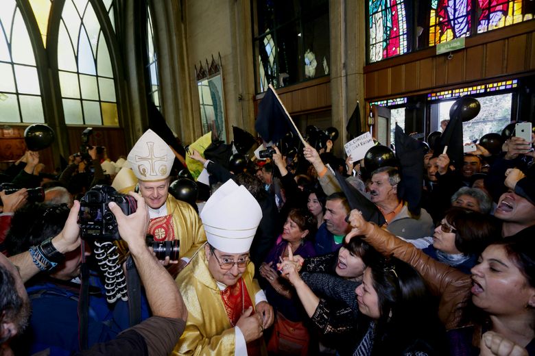 Protestors shout as bishops and priests  enter the cathedral to attend the ordination ceremony as bishop of Rev. Juan Barros  in Osorno, southern Chile, Saturday, March 21, 2015.  Barros was ordained amid protests by sex-abuse victims who accuse him of covering up crimes of his mentor  Rev. Fernando Karadima  whom the Vatican has sanctioned for abusing young boys.(AP Photo/Mario Mendoza Cabrera) CHILE OUT – NO USAR EN CHILE