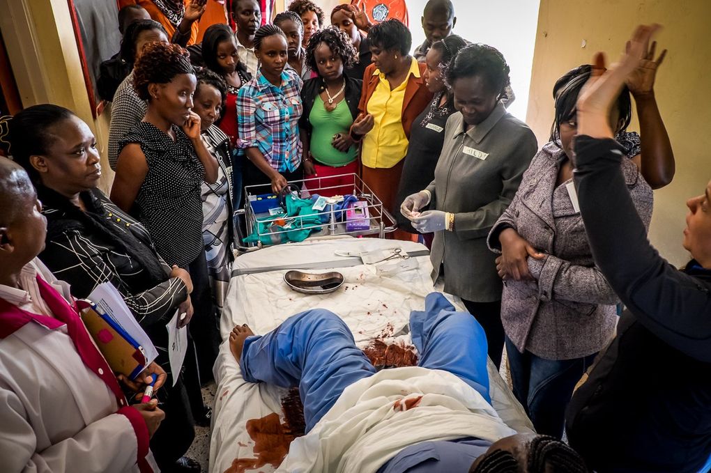 During a childbirth simulation using fake blood, nurses and midwives crowd around a hospital bed in Naivasha, Kenya. The training sessions, designed by Seattle-based PRONTO International, use low-tech but realistic teaching tools to recreate the chaos often found in Kenya’s overburdened maternity wards. (Paul Nevin)
