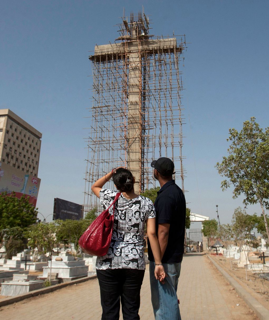 A Pakistani Christian couple look at a 140-foot cross, under construction at a cemetery in the center of Karachi, Pakistan. The cemetery is nearly 200 years old, and its administrators will take care of the cross once it’s constructed.  (Shakil Adil/AP)