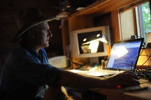 Twice a day, Range Rider Bill Johnson logs on to his computer to look at GPS tracking data of collared wolves in the Teanaway Valley area. (Sy Bean / The Seattle Times)