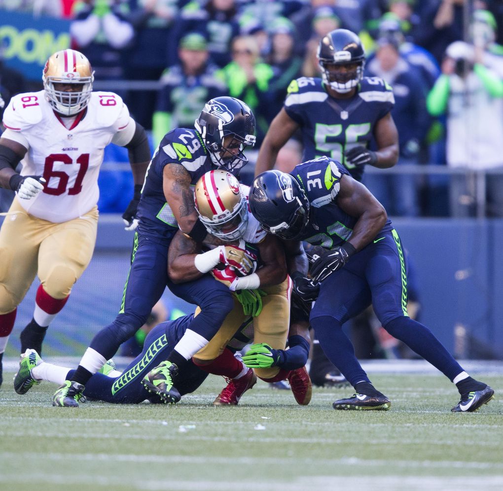 Seahawks safety Earl Thomas, left, and Seahawks safety Kam Chancellor gang up to stop 49ers running back Shaun Draughn in the first quarter at CenturyLink Field on Nov. (Dean Rutz/The Seattle Times)