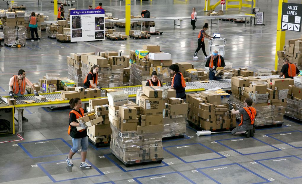 Employees work inside Amazon’s 300,000-square-foot sorting center in Kent. The center allows Seattle-area residents to order some items as late as 11:59 p.m. (ERIKA SCHULTZ/THE SEATTLE TIMES )