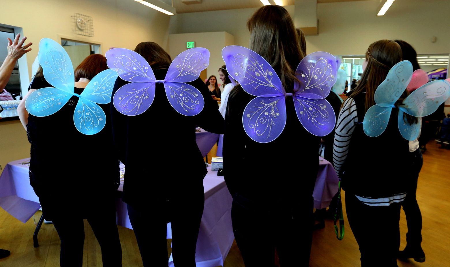 Winged volunteer fairy godmothers gather Saturday at Meadowbrook Community Center in North Seattle to set out items for the project that Nathan Hale High senior Alexa Landis organized to provide girls everything they need for their prom, and all for free. (Alan Berner/The Seattle Times)