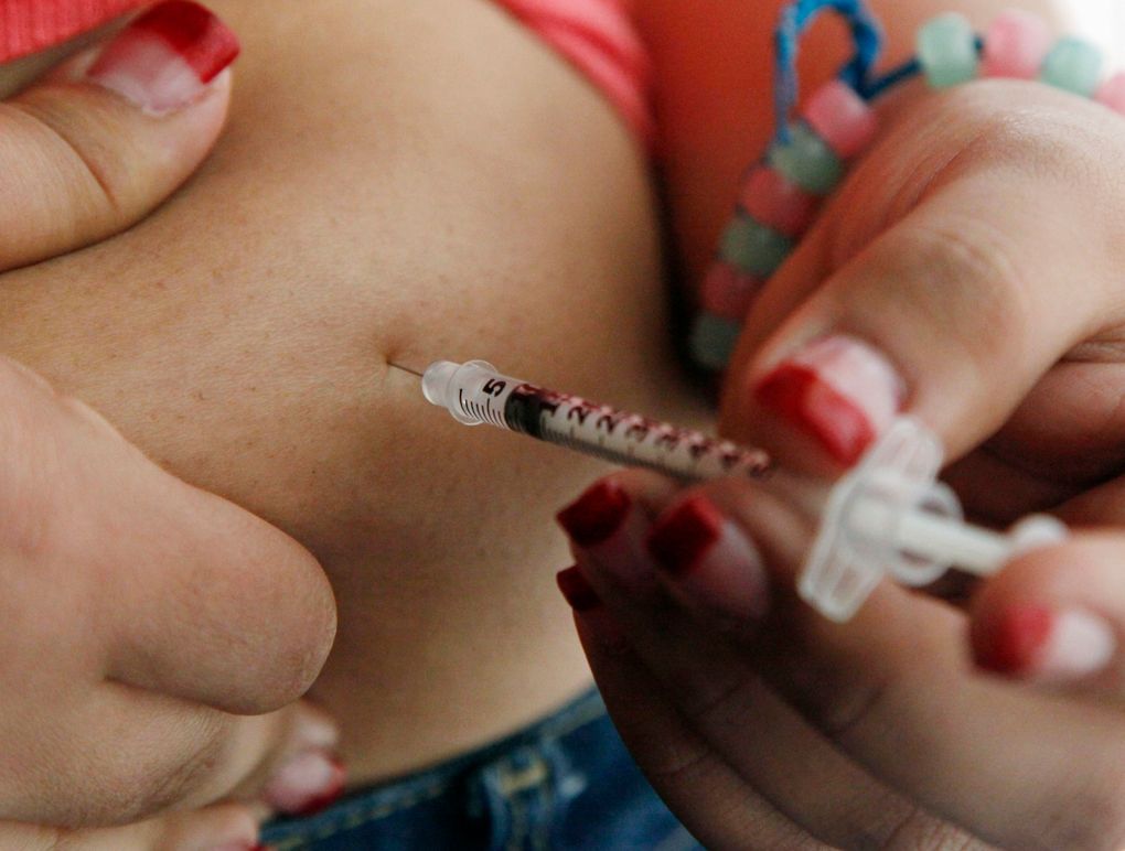 FILE – In this April 29, 2012 file photo, a woman diagnosed with diabetes gives herself an injection of insulin at her home in the Los Angeles suburb of Commerce, Calif. (AP Photo/Reed Saxon, File)
