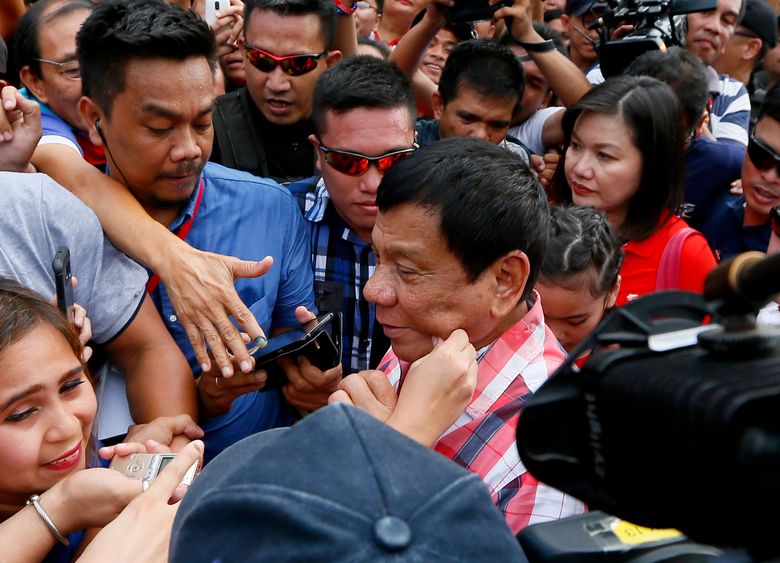 FILE – In this May 9, 2016 file photo, a supporter pinches the cheek of front-running presidential candidate Mayor Rodrigo Duterte as he leaves Daniel R. (AP Photo/Bullit Marquez, File)