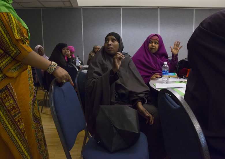 Halima Maalim, a local child-care provider, center, chats with other care providers in one of the breakout groups May 28 during Voices of Tomorrow’s second annual conference, at the Tukwila Community Center. (Sy Bean/The Seattle Times)