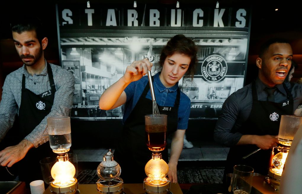 Starbucks workers prepare coffee using siphon vacuum coffee makers at the coffee company’s annual shareholders meeting in Seattle in March. (Ted S. Warren/AP)