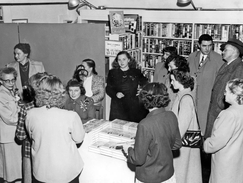 Betty MacDonald (seated, with corsage) signs ” The Plague and I” at University Book Store, Seattle, in 1948. Her sister Mary Bard Jensen stands in back row left. The author’s husband, Don MacDonald, stands in the back row, second man from the right.