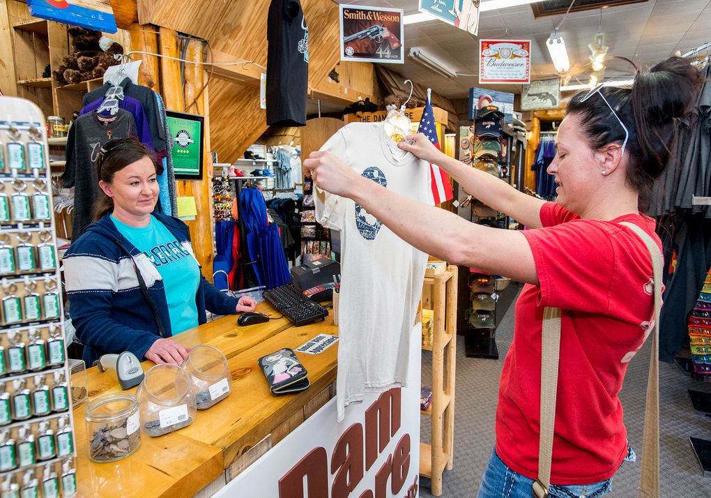 FILE – In this Friday, Oct. 21, 2016, file photograph, Sara Judge, left, manager of the Dam Store, located at the mouth of the Big Thompson Canyon, helps customer Jessica Wiechman, right, from West Point, Neb., with a purchase, in Loveland, Colo. (Michael Brian/Loveland Reporter-Herald via AP, File)