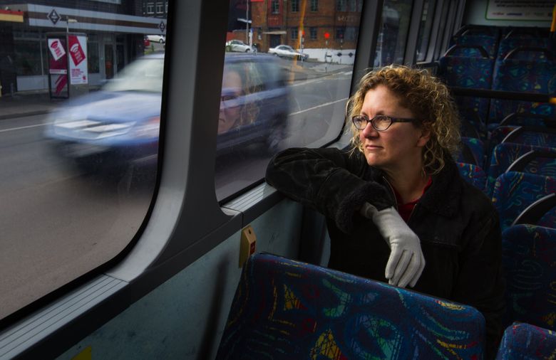 Ann Brower sits on a bus like the one she rode downtown when the February 2011 earthquake hit Christchurch, New Zealand. (Ellen M. Banner/The Seattle Times)