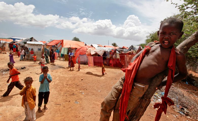 In this photo taken Wednesday, Nov. 16, 2016, Somali children who were repatriated to Somalia from Kenya’s Dadaab camp, play in front of makeshift shelters in the Daryeel camp for the displaced, in Mogadishu, Somalia. (AP Photo/Farah Abdi Warsameh)