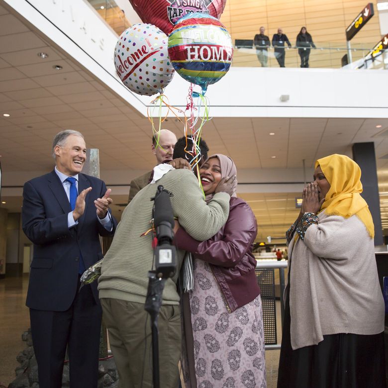 Gov. Jay Inslee applauds as a Somali immigrant, Isahaq Ahmed Rabi, is hugged by family members on his arrival at the Seattle-Tacoma International Airport. Because of the president’s executive order on immigration he had earlier been turned away when attempting to join his wife, a U.S. citizen. (Bettina Hansen/The Seattle Times)
