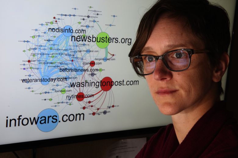 Kate Starbird, a University of Washington assistant professor in the Department of Human Centered Design & Engineering, with a domain network graph she developed looking at tweets relating to 2016 shootings. (Ken Lambert/The Seattle Times)