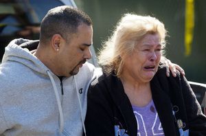 Sylvia Valdovinos, mother of shooting victim Ceasar Valdovinos, is comforted by son Richard Ruiz. Ceasar was visiting at the Pinewood Village Apartments when gunfire broke out. 