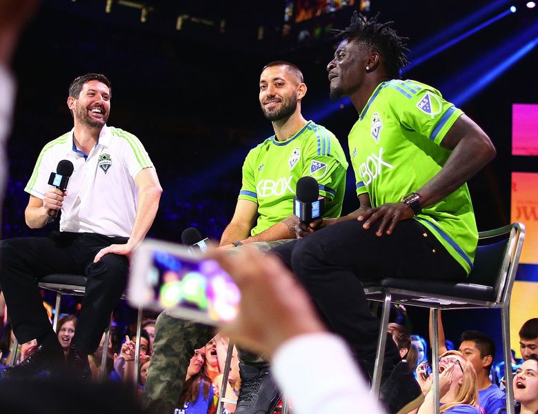 Sounders announcer Ross Fletcher, left, interviews players Clint Dempsey, center, and Obafemi Martins during We Day at KeyArena. (John Lok/The Seattle Times)