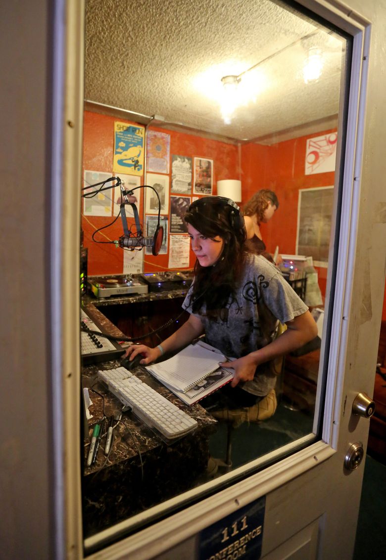 Hollow Earth Radio DJ Carly Dunn, foreground, gets ready to start streaming her show online. (Greg Gilbert/The Seattle Times)