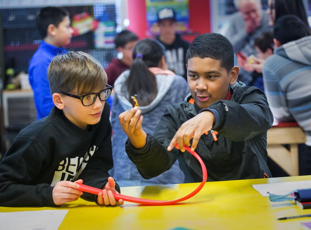 Seventh-graders Renat Sidorko, left, and Brett McGlone use a toy car and track to consider how to measure and calculate speed using distance and time during their seventh-grade science class at Federal Way Public Academy. (Mike Siegel/The Seattle Times)