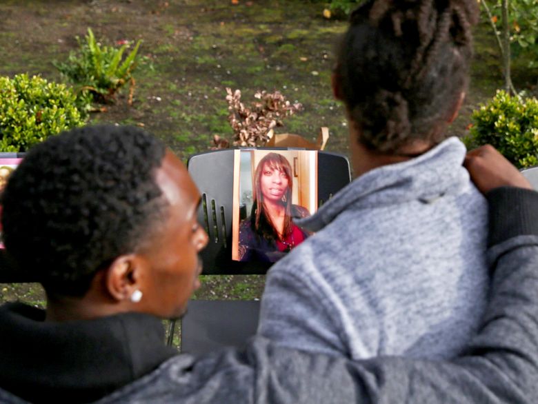 People attend a memorial for Charleena Lyles, seen in a photo at center, who was fatally shot by Seattle police on Sunday in Seattle's Magnuson Park. (Ken Lambert / The Seattle Times)
