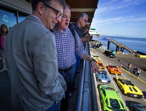 Roger Townsend, left, and Geoff Entress watch as the Lamborghinis board a ferry to Bainbridge Island on Friday. (Mike Siegel/the Seattle Times)