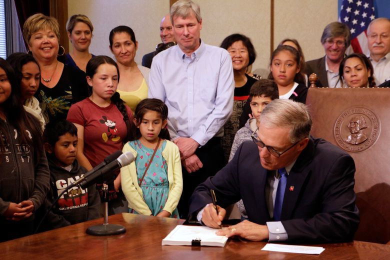 Washington Gov. Jay Inslee signs into law a measure that seeks to bring the state into compliance with a court mandate to increase state dollars to basic education Thursday, July 6, in Olympia. Washington state has been in contempt of court for lack of progress on satisfying a 2012 state Supreme Court ruling that found that school funding was not adequate. (AP Photo/Rachel La Corte)  (Rachel La Corte/AP)