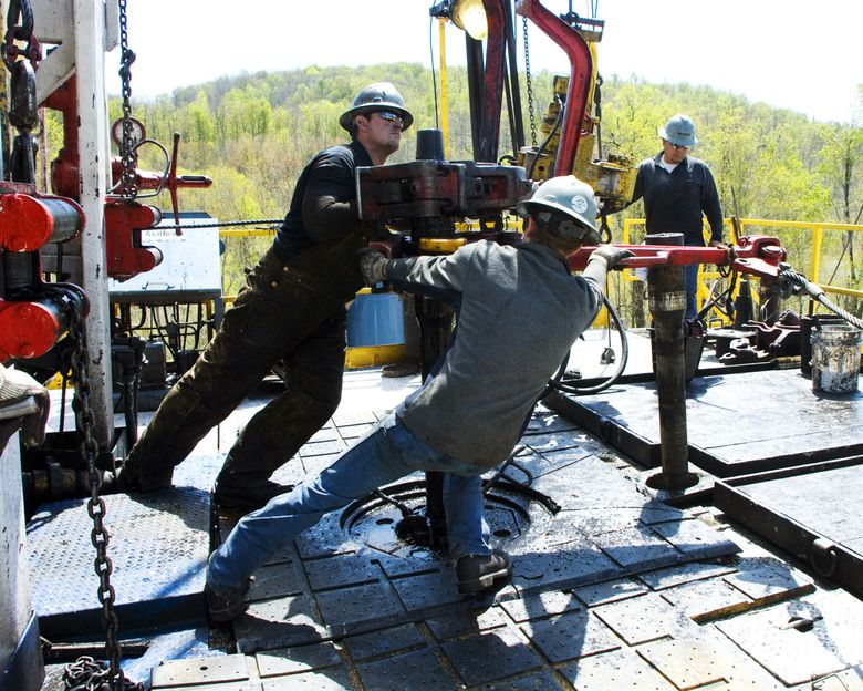 Workers move a well casing at a Chesapeake Energy natural gas well site near Burlington, Pa.  (Ralph Wilson / The Associated Press)