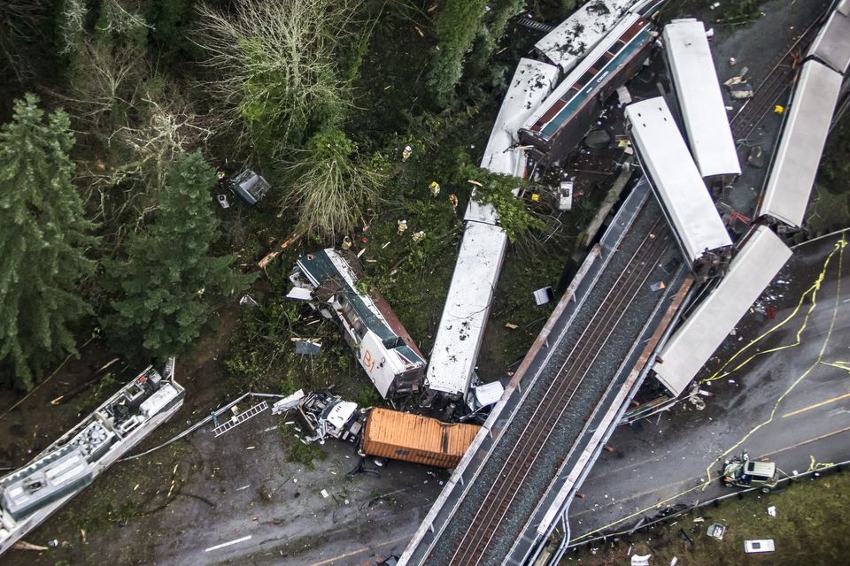 Emergency crews work after an Amtrak train derailed, falling off a bridge and onto Interstate 5 near Mounts Road between Dupont and Olympia, Washington, on Monday. The lead engine can be seen at left.  Photograph: Bettina Hansen/The Seattle Times.