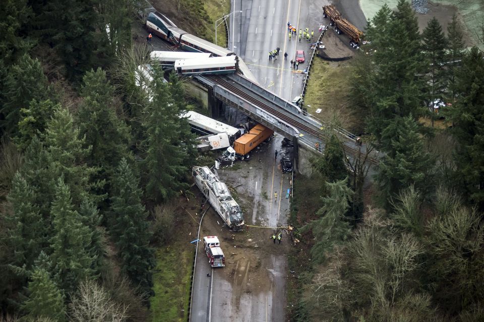 An Amtrak train derailed and fell off a bridge, landing on Interstate 5 between Dupont and Olympia, Washington, on Monday. The lead engine can be seen in the southbound lanes near a firetruck.  Photograph: Bettina Hansen/The Seattle Times.