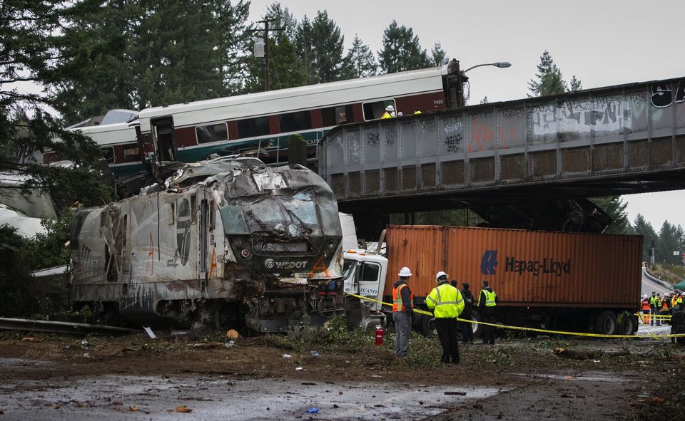 The lead engine and wreckage of an Amtrak train sit in the southbound lanes of Interstate 5 after the Monday morning derailment south of Dupont.  Photograph: Ellen M. Banner/The Seattle Times.