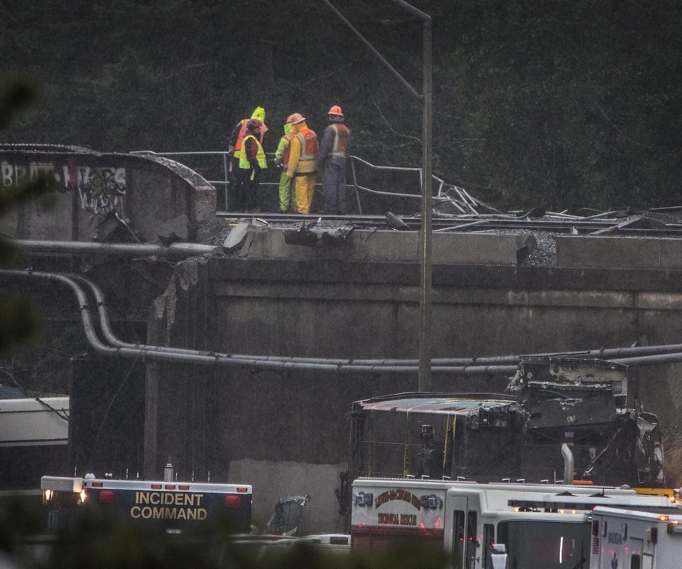 The investigation continues throughout Tuesday on the freeway overpass where an Amtrak Cascades train derailed on Monday. — Photograph: Steve Ringman/The Seattle Times.