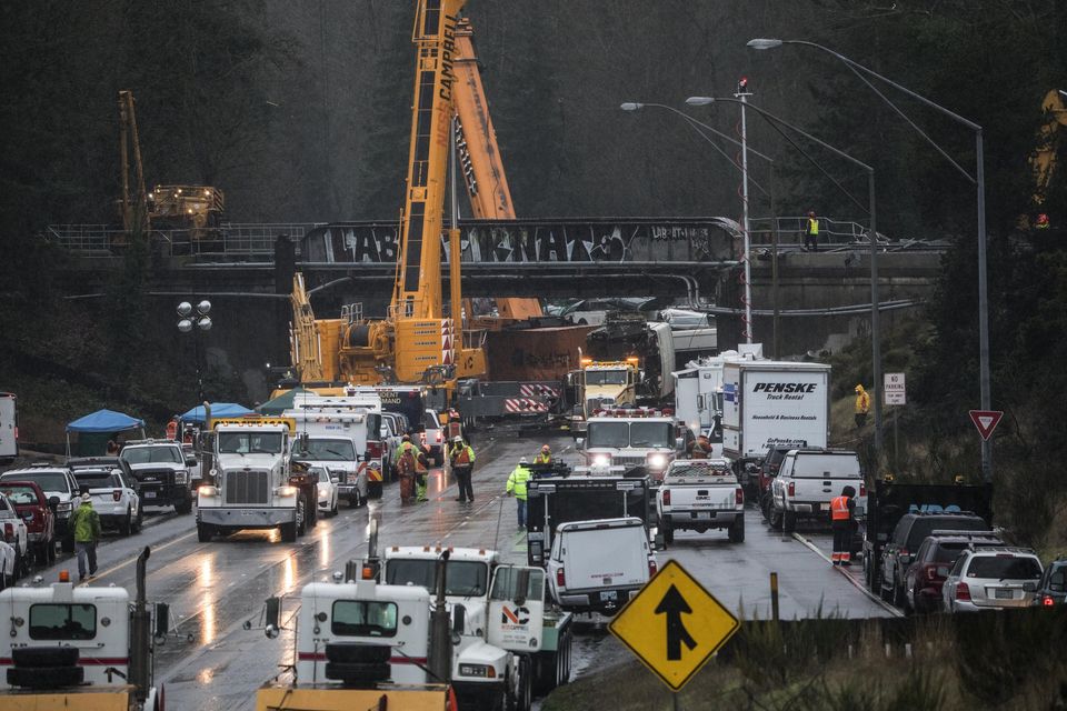 This view, looking south along Interstate 5, shows the continuing derailment investigation as well as the effort to remove the damaged cars from the scene near DuPont. — Photograph: Steve Ringman/The Seattle Times.