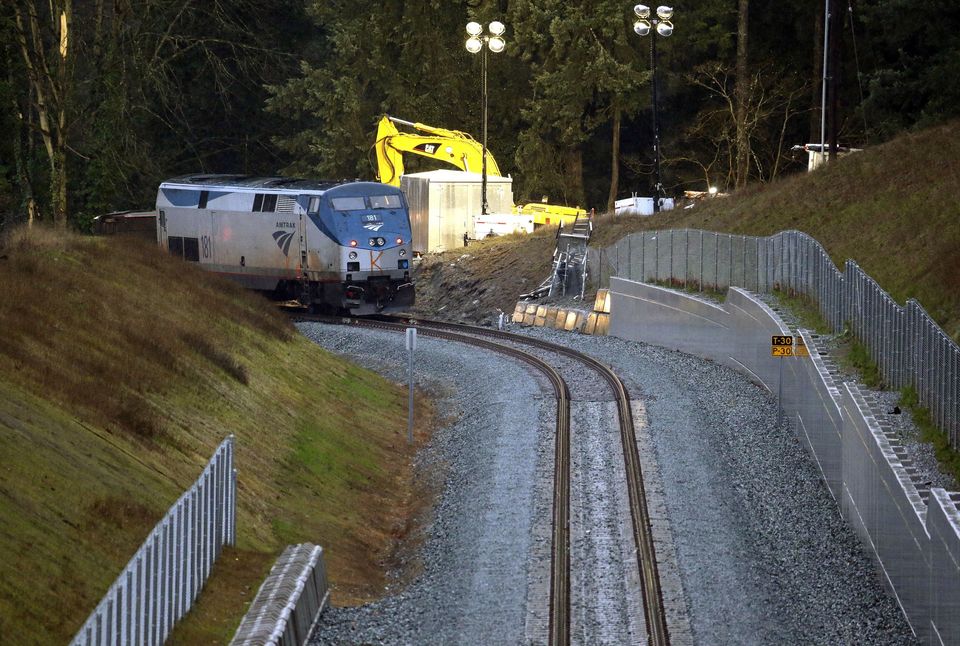 The rear car of a crashed Amtrak train remained standing early Tuesday where the southbound tracks make a curve to the left. The train that plunged off an overpass at that site was going much higher than the speed limit, federal authorities said. — Photograph: Elaine Thompson/The Associated Press.