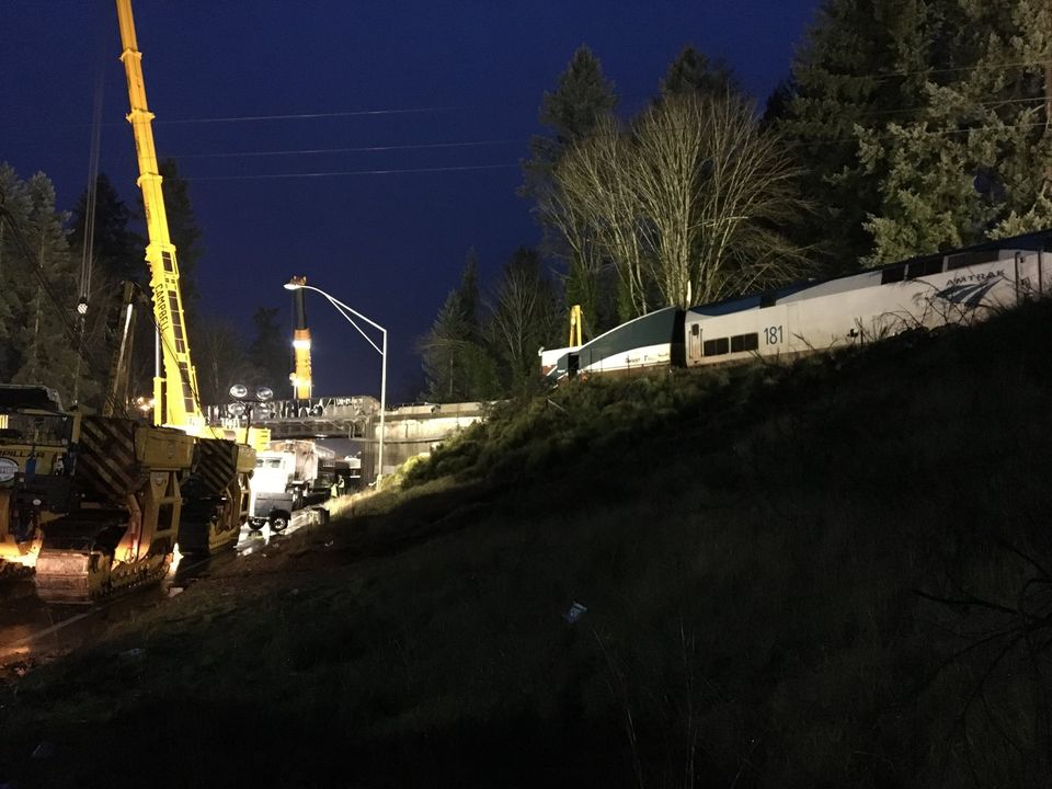 Crews began to remove derailed train cars on the trestle early Tuesday, but wreckage remained visible below. — Photograph: Christine Clarridge/The Seattle Times.