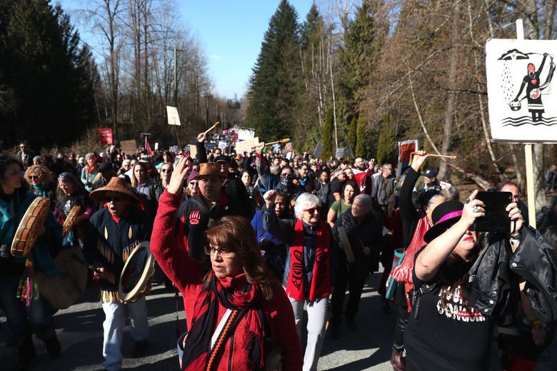 Thousands participate in a march against the expansion of the Trans Mountain pipeline expansion near the Kinder Morgan tank farm in Burnaby, British Columbia, Saturday, March 10, 2018. The company is to build 14 additional tanks, three more berths and a tunnel through the mountain for a new pipeline, to triple the volume of diluted bitumen oil carried. (Courtney Pedroza/The Seattle Times via AP)