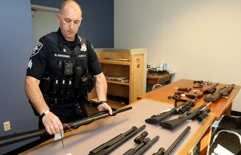 On May 23, 2018, Seattle Police Crisis Response Team Sgt Eric Pisconski displays guns seized from people deemed to be a danger to themselves or others. 206407