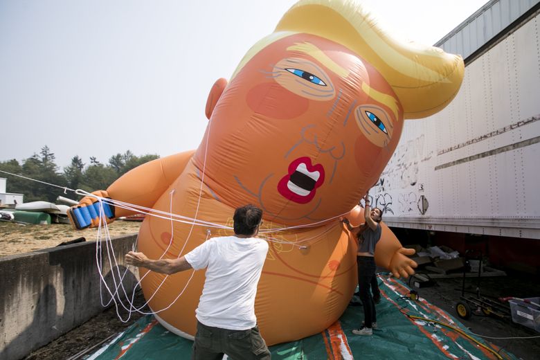 Art Chippendale and Roni Murray, right, help the Backbone Campaign try out their new inflatable “Trump Baby” at their workspace on Vashon Island on Monday.  (Bettina Hansen/The Seattle Times)