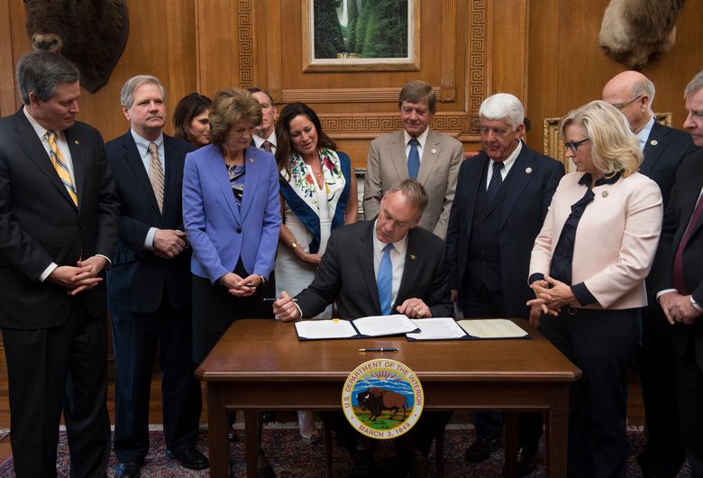 In this March 29, 2017, photo, Interior Secretary Ryan Zinke, accompanied by Republican members of Congress, signs an order lifting a moratorium on new coal leases on federal lands and a related order on coal royalties, at the Interior Department in Washington. From left are Senator Steve Daines (Republican-Montana), Senator John Hoeven, Republican-North Dakota), Senator Lisa Murkowski (Republican-Alaska), Zinke's wife, Lolita, Representative Scott Tipton (Republican-Colorado), Representative Rob Bishop (Republican-Utah) and Representative Liz Cheney (Republican-Wyoming). — Photograph: Molly Riley/Associated Press.