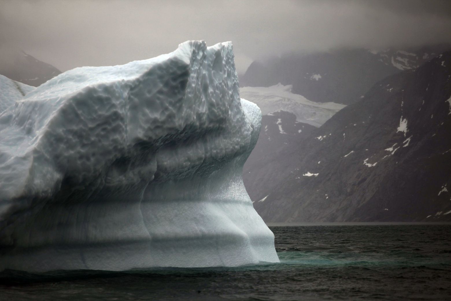 A melting iceberg floats along a fjord leading away from the edge of the Greenland ice sheet near Nuuk, Greenland, in 2011. By this century's end, if emissions continue at their current pace, humans will have warmed the ocean about 20 percent, as much as during the Permian extinction event, newly published research says. — Photograph: Brennan Linsley/The Associated Press.