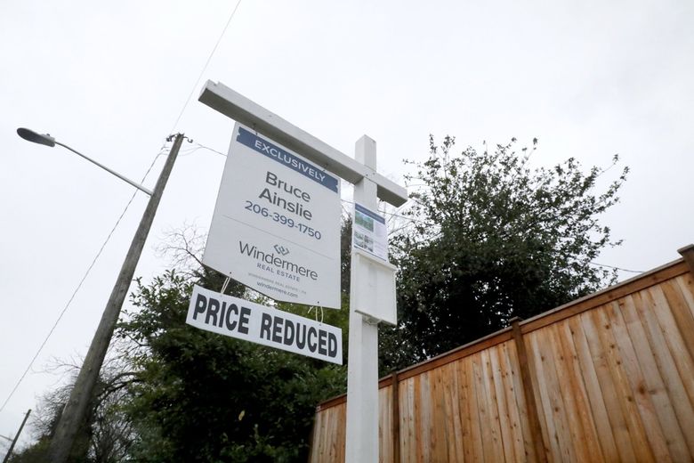 A home for sale north of Seattle’s Roosevelt neighborhood has a sign added to the bottom informing buyers that the asking price has been lowered. (Greg Gilbert / The Seattle Times)