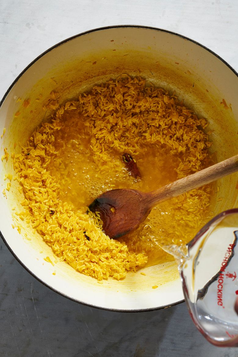 Yellow rice is prepared, to serve with lentils.  (David Malosh/The New York Times)