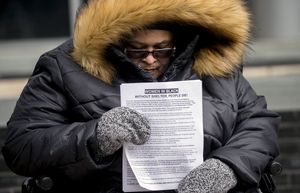 Qweenâ€™B King-Rios keeps vigil with the Women in Black of WHEEL, the Womenâ€™s Housing, Equality and Enhancement League, outside the Seattle Municipal Court building downtown Wednesday February 13, 2019. They stand vigil for people experiencing homelessness who die outside or by violence. King-Rios holds a paper with the names of 11 women and men who died in January of 2019 and Derek C. Johnson, who was found dead of hypothermia near the Sodo light rail platform last week. 209323