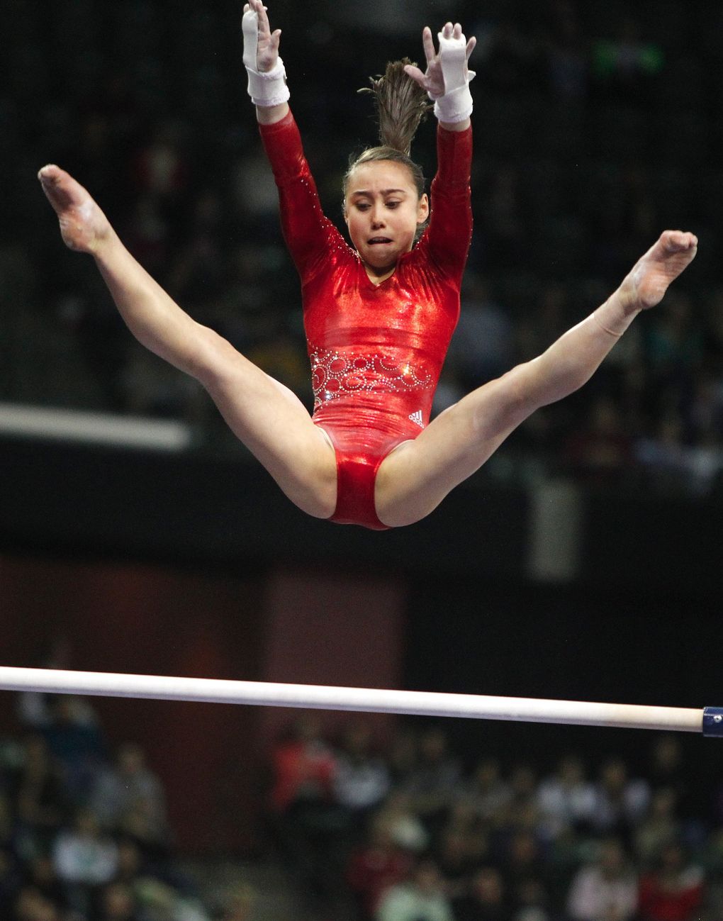 USA’s Katelyn Ohashi soars over the top bar during her routine on the un-ev...