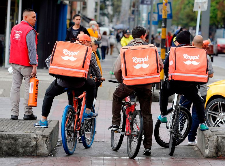 Venezuelan nationals work as bicycle couriers for the Colombian online-delivery company Rappi, seen here aboard their bikes in Bogota. (John Vizcaino/AFP/Getty Images/TNS, file) 