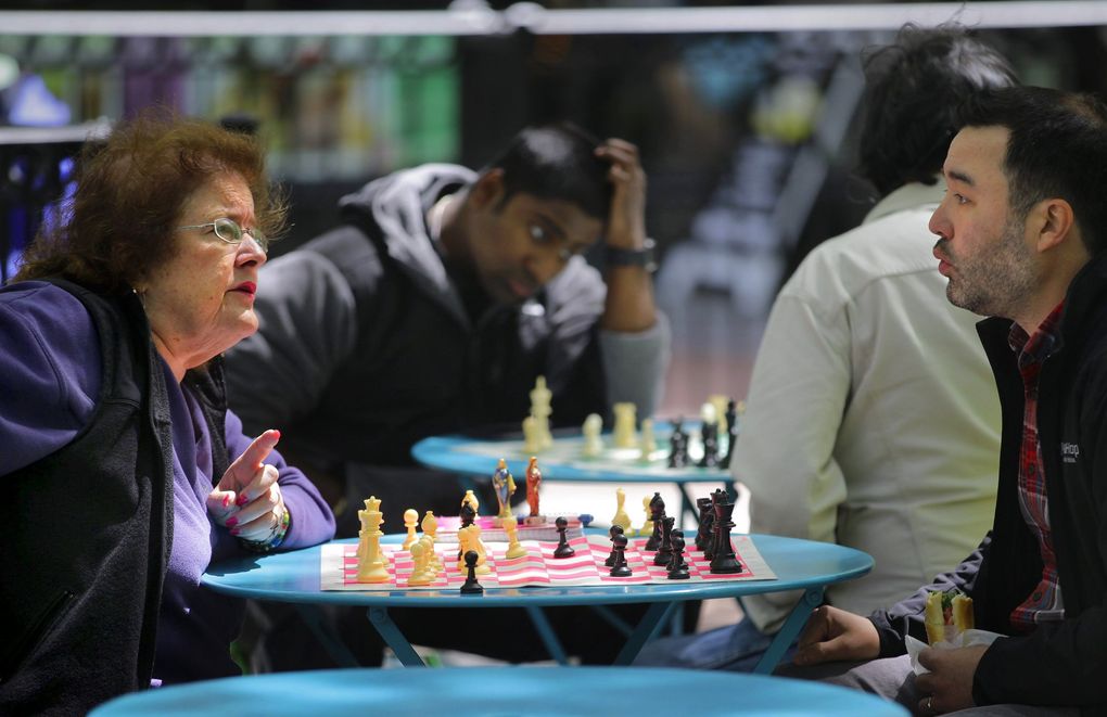 Chess lover Karen Schmidt, left, plays a lunchtime game of chess with Tyson Supasatit at Westlake Park in downtown Seattle. Supasatit works nearby at ExtraHop Networks. Schmidt is often the only woman looking for chess games at Westlake, where the city has set up boards to promote healthy, intellectually rigorous entertainment. (Mike Siegel / The Seattle Times)