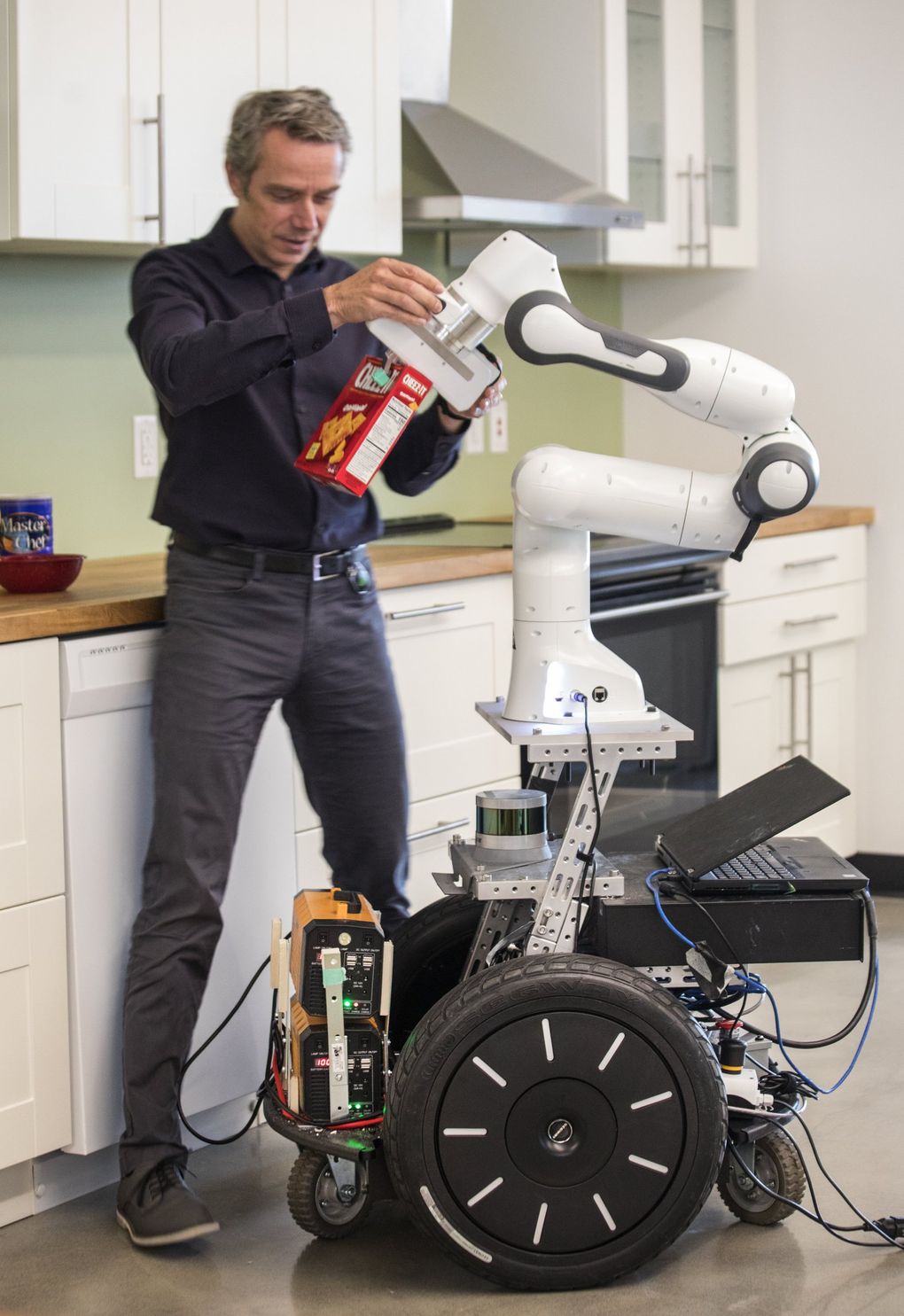 At the NVIDIA robotics lab in Seattleâs University District, lab head Dieter Fox works with an AI-powered robot in a simulated kitchen environment.   (Steve Ringman / The Seattle Times)