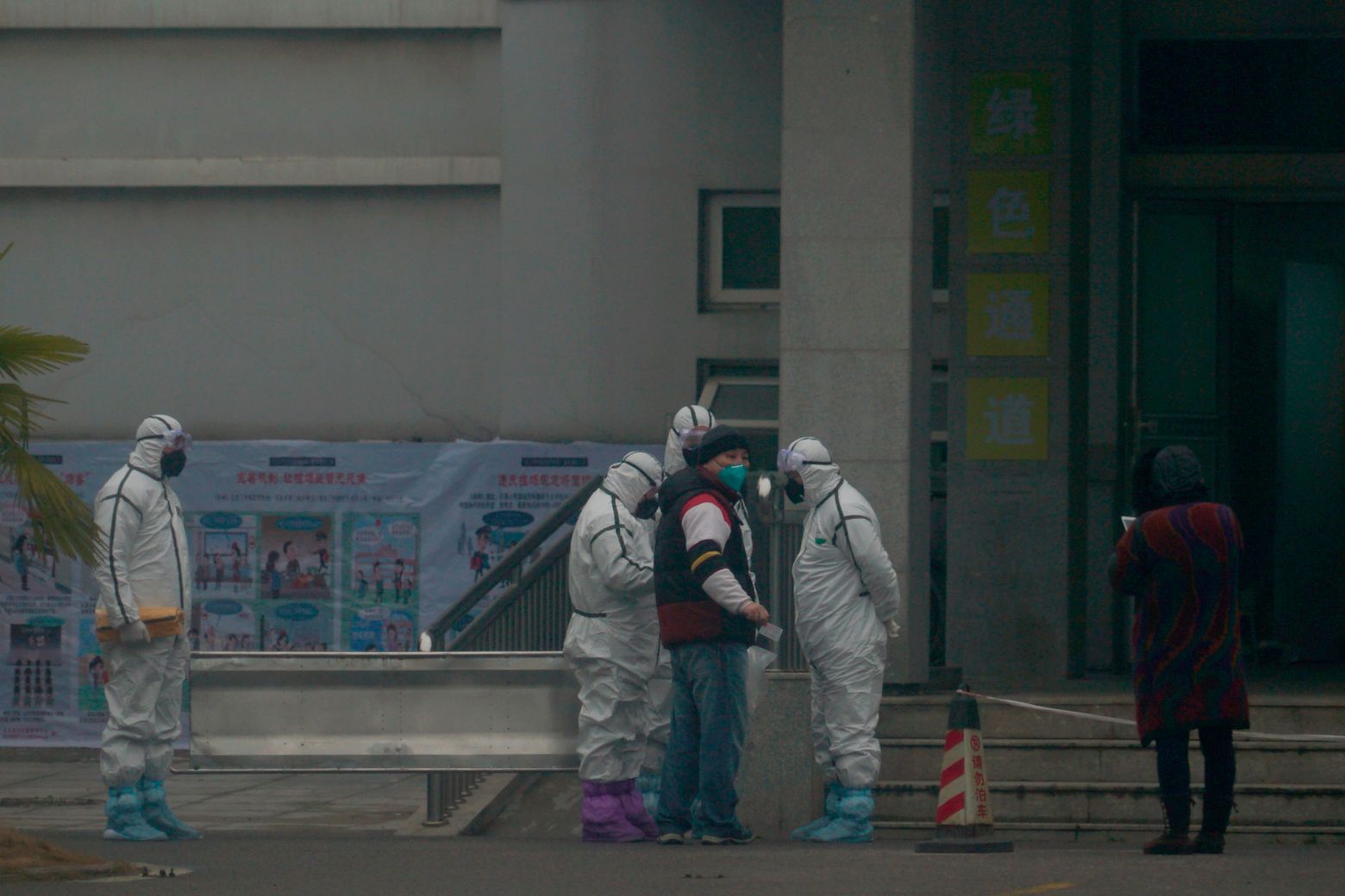 Staff in biohazard suits hold a metal stretcher by the in-patient department of Wuhan Medical Treatment Center, where some infected with a novel coronavirus are being treated, in Wuhan, China, Tuesday, Jan. 21, 2020. Heightened precautions were being taken in China and elsewhere Tuesday as governments strove to control the outbreak of the coronavirus, which threatens to grow during the Lunar New Year travel rush. (AP Photo/Dake Kang)