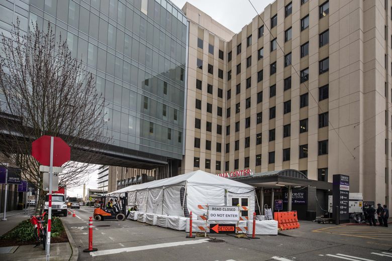 Tents sit at Harborview Medical Center’s emergency room on Thursday to keep respiratory patients separate from others in the hospital while they are evaluated.    (Steve Ringman / The Seattle Times)