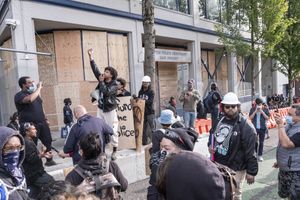 12番街とイースト・パイン・ストリートの交差点に入ったデモ参加者は、次の行動を計画し、シアトル警察署のイースト分署を破壊しないよう警告している。 (Dean Rutz / The Seattle Times)