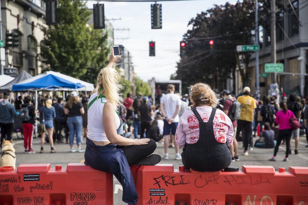 Demonstrators tape speakers on 12th Avenue and Pine Street on Wednesday in the Capitol Hill Autonomous Zone, which was named by protesters after law enforcement left the area earlier this week. (Amanda Snyder / The Seattle Times)