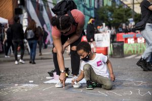 ザンダー・キャノン（5歳）と母親のファロン・シエラは水曜日、11番街とパイン・ストリートの交差点で虹を描いていた。 (Amanda Snyder / The Seattle Times)